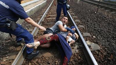 Familia de refugiados se aferra a las vías del tren para evitar ser deportados (VIDEO)