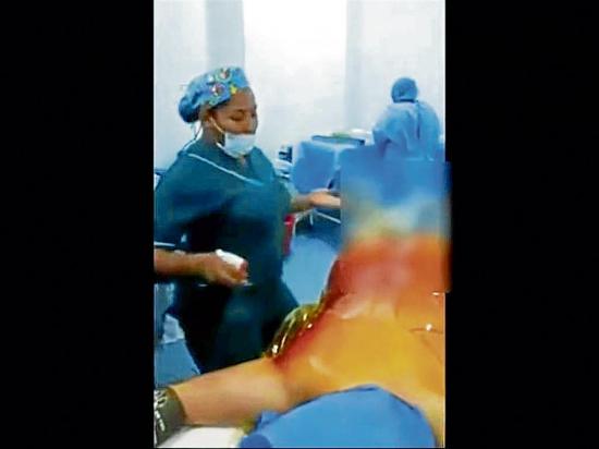 Médicos y enfermeras bailan frente a una paciente desnuda