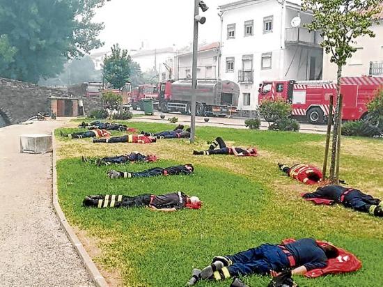 Foto de bomberos agotados  sobre el césped se hace viral